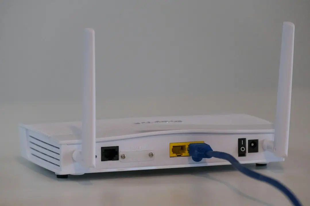 A white Wi-Fi router with an Ethernet cable plugged in, the first thing to check when an IPTV stream buffers